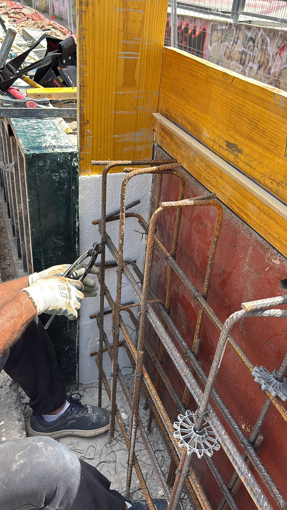 Trabajador atando ferralla con alambre en una jaula de armado