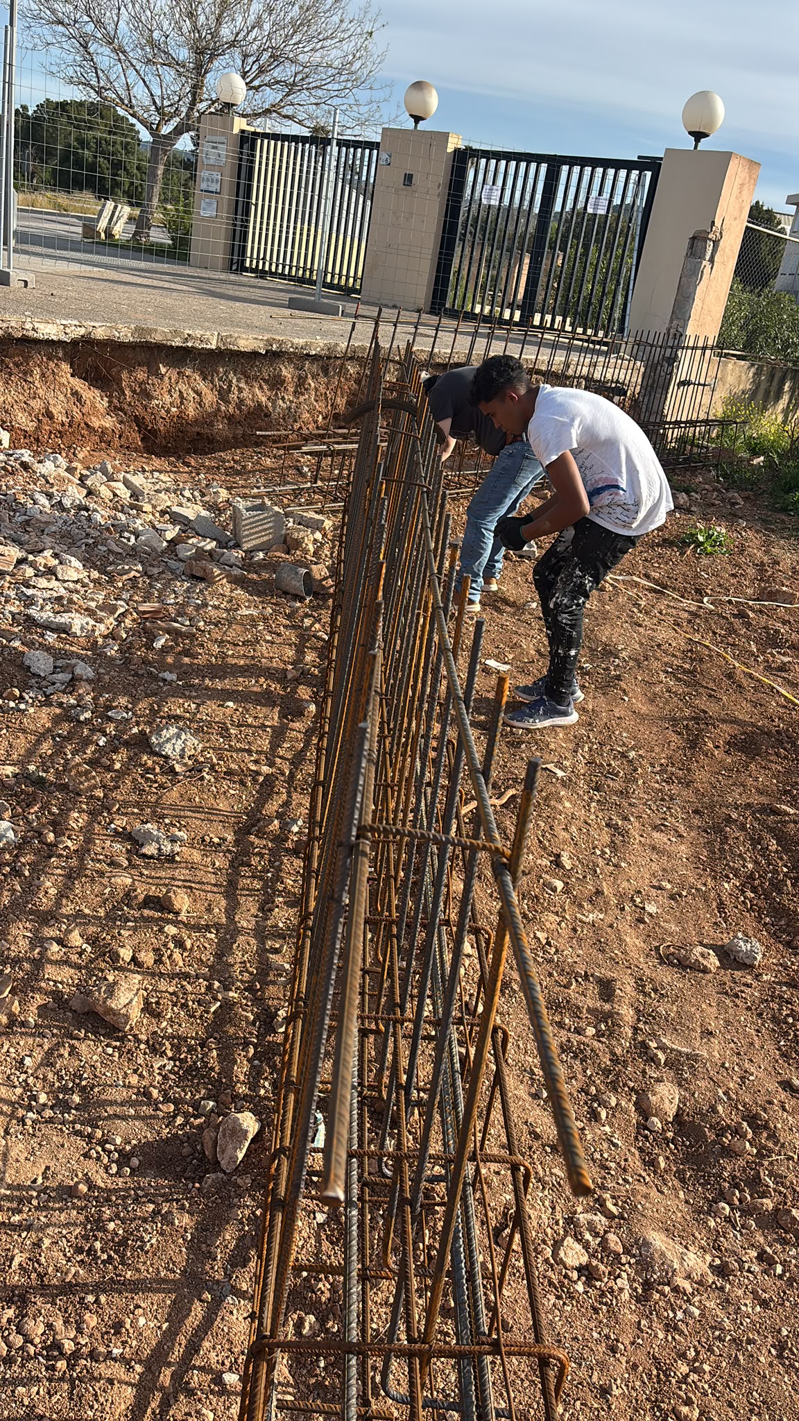 Dos trabajadores montando una jaula de ferralla en el suelo