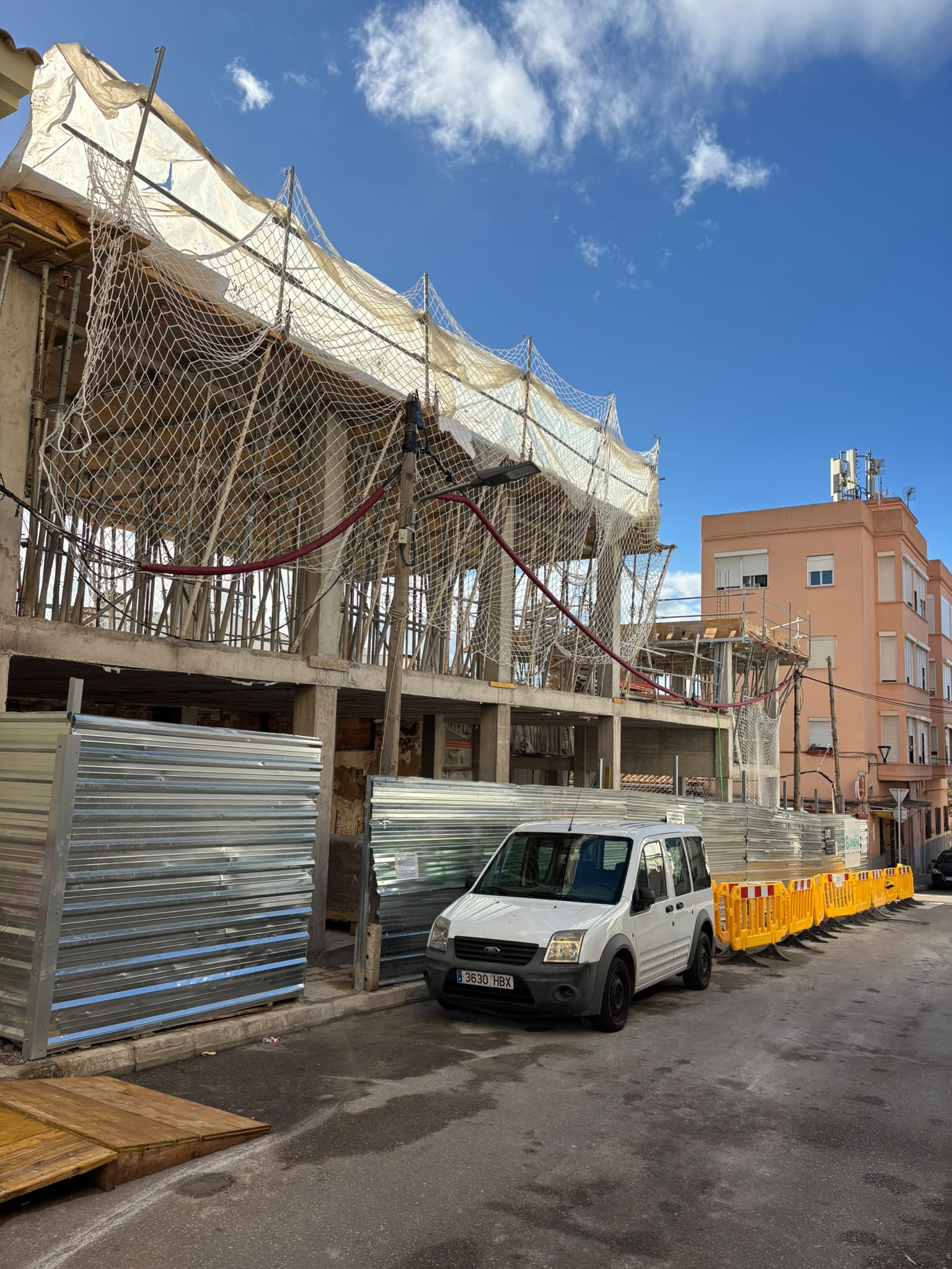 Edificio en construcción con red de protección y andamios